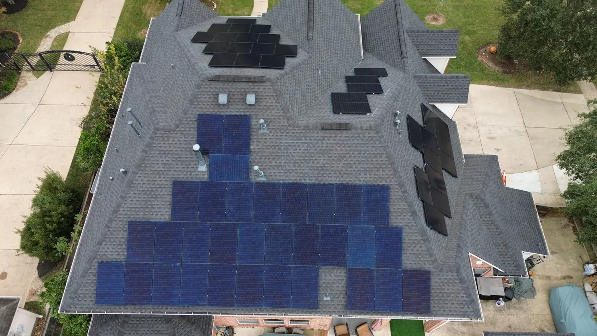 Aerial view showing solar arrays arranged across multiple roof sections