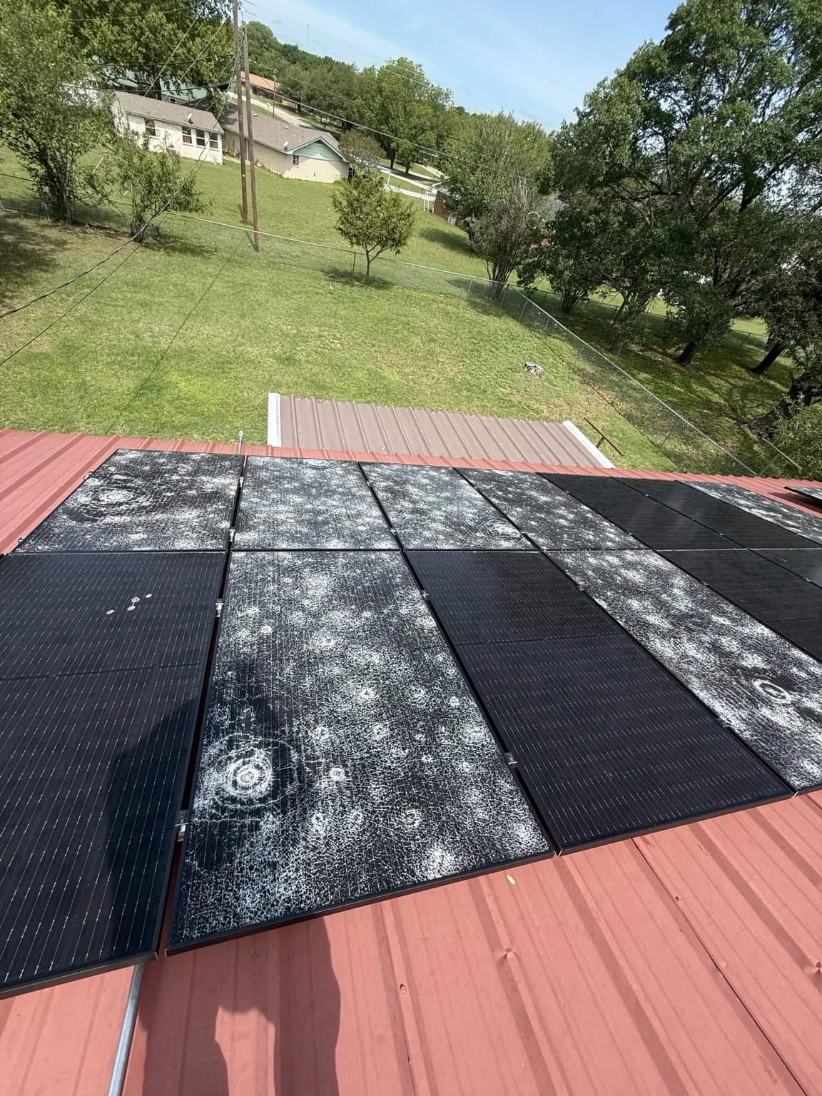 Several rooftop solar panels with visibly cracked glass