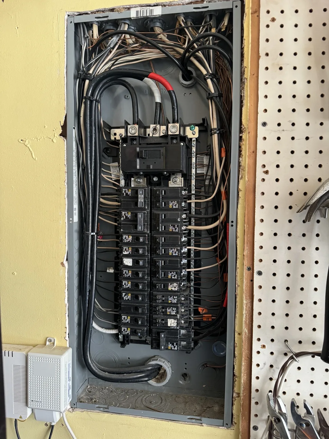 Open electrical panel with breakers and wiring during service