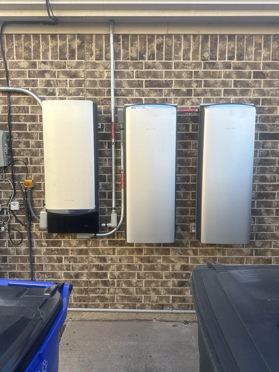 Battery and inverter equipment mounted on an exterior brick wall
