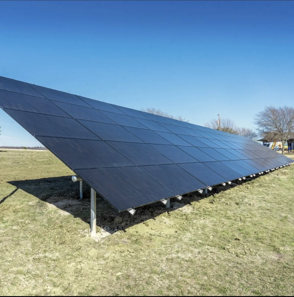 Ground-mounted solar panels on a grassy property
