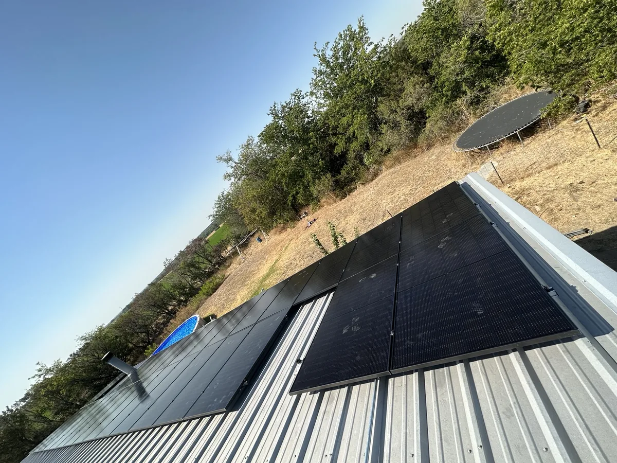 Solar panel sections arranged around a metal-roof vent