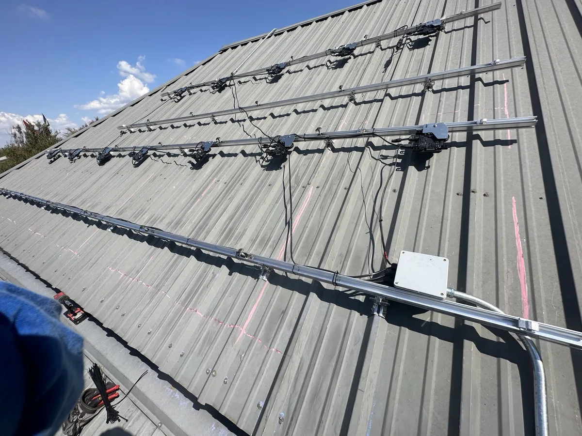 Mounting rails, microinverters and conduit on a metal roof