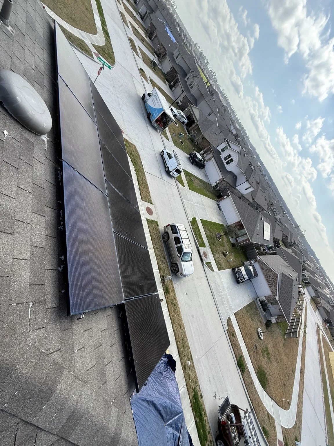 Solar panels on a shingle roof above a residential street