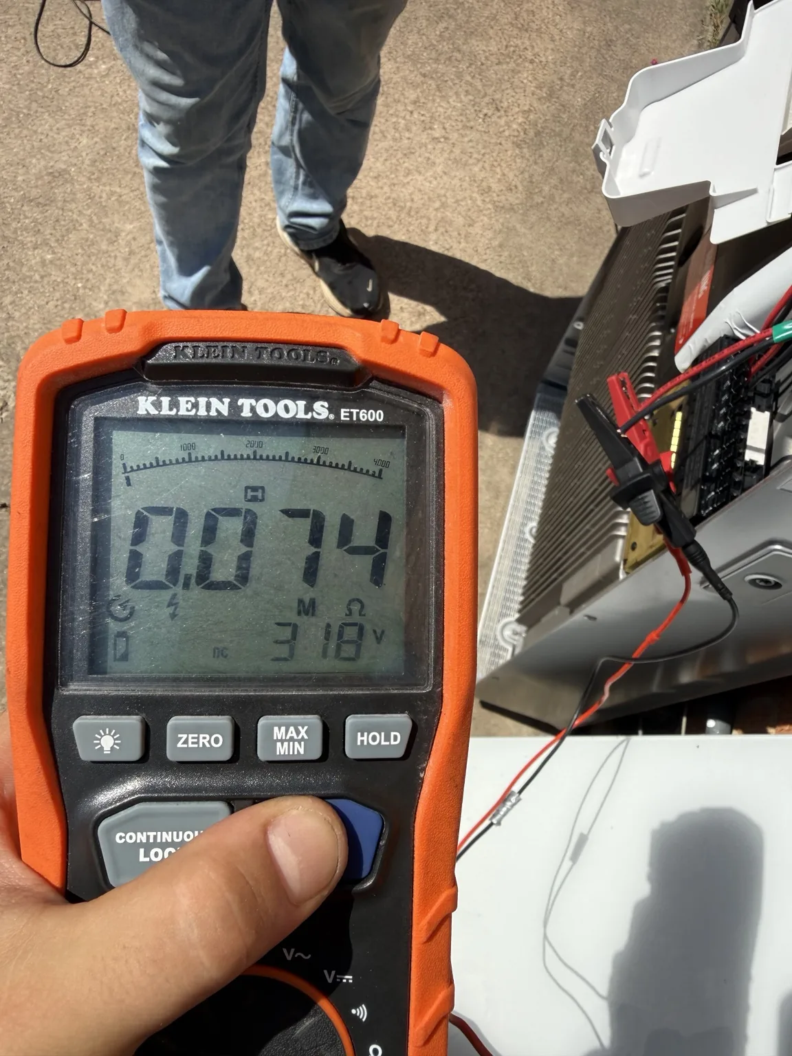 Insulation-resistance tester beside open solar equipment