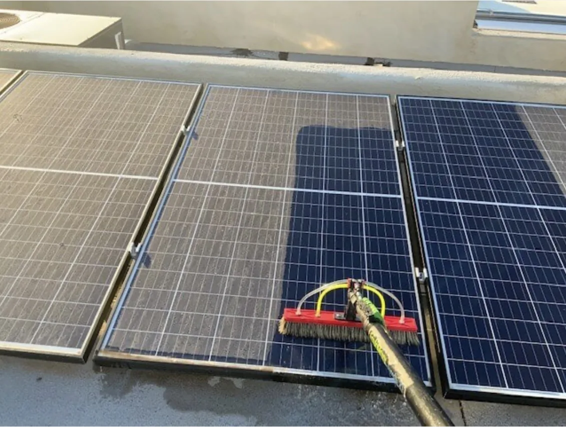 Cleaning brush on solar panels showing areas of surface buildup